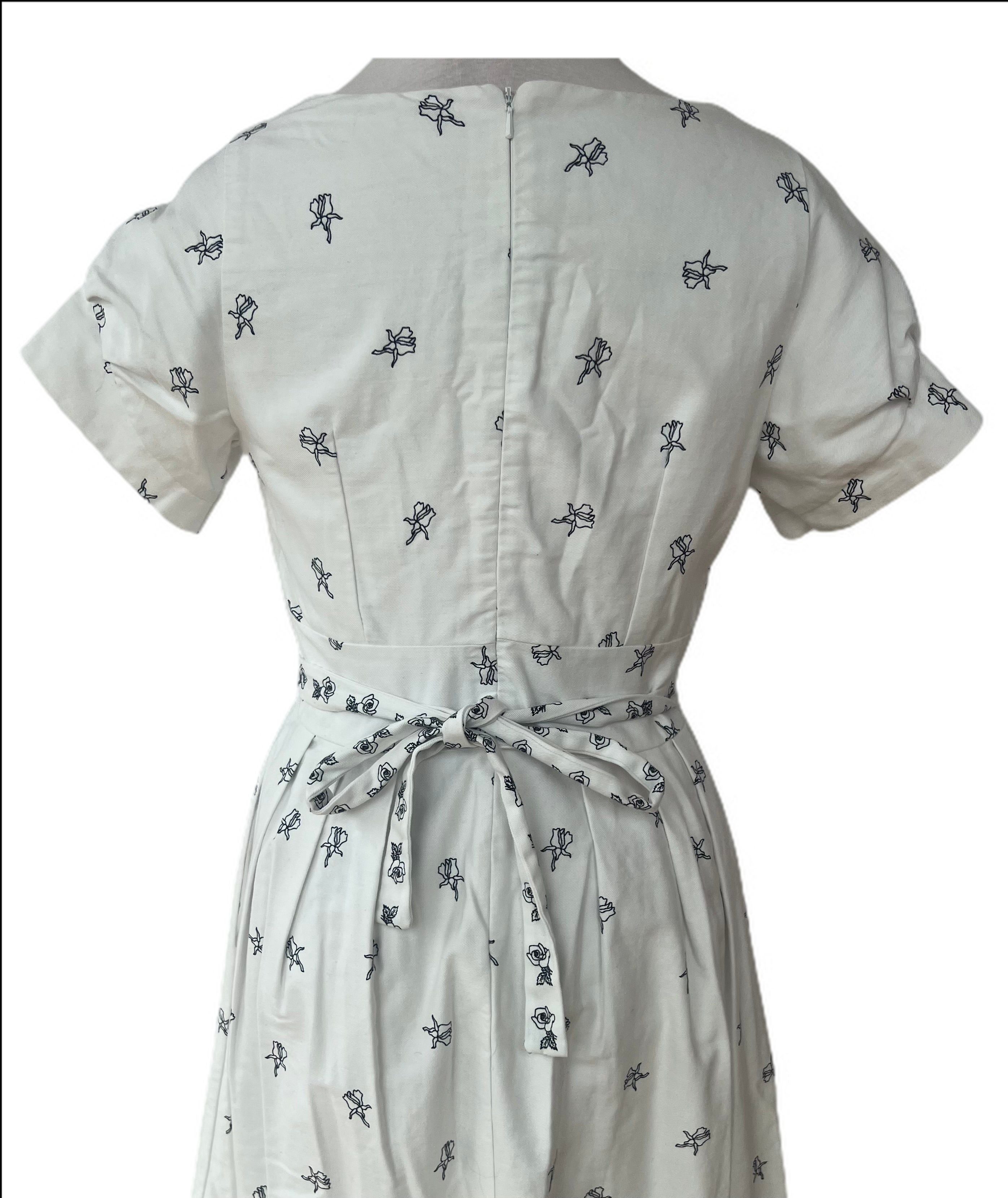 Gorgeous white apron style short sleeve dress with black flowers is made in England