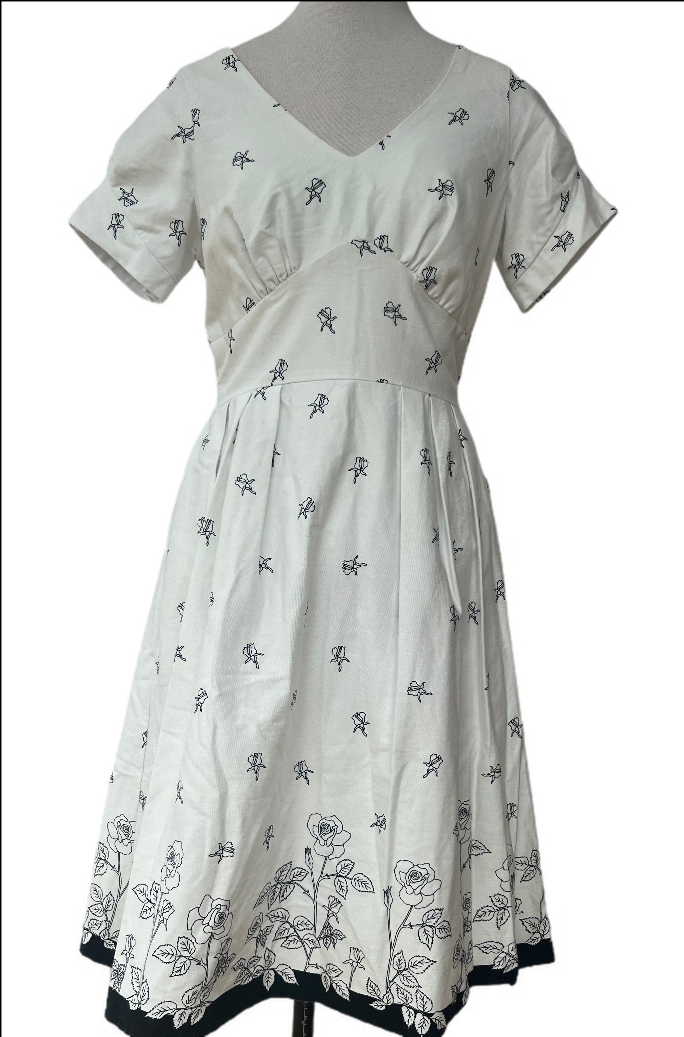 Gorgeous white apron style short sleeve dress with black flowers is made in England